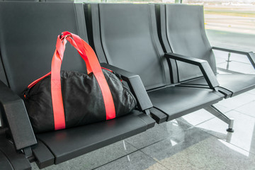 Suspicious black sport bag left on chairs unattended. Lost luggage. Concept of safety in public...