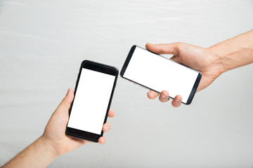Close up hand's two young man using smart phone with blank white screen for your advertising picture or text message.