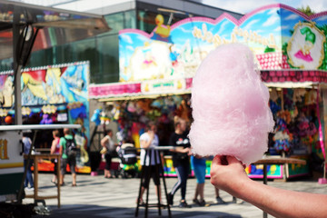 Obraz premium amusement park eating white cotton candy. enjoying a day at amusement park with fresh cotton candy in hand