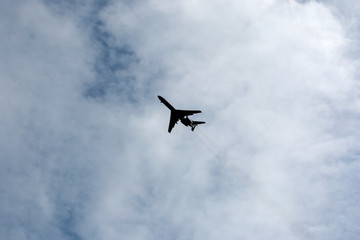 the plane flies across the blue sky