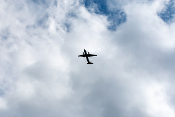 the plane flies across the blue sky