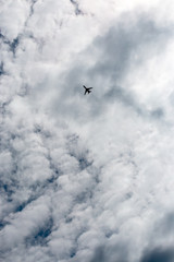 the plane flies across the blue sky