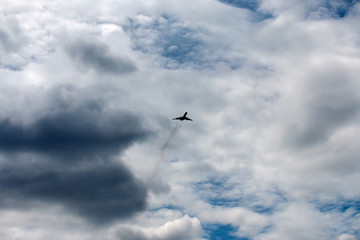 the plane flies across the blue sky
