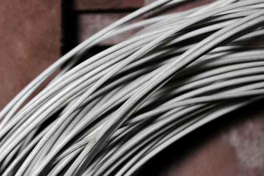 a coil of fechral thick refractory wire hangs in a warehouse of goods for ceramists. Frame of coiled nichrome wire for heating element
