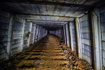 Dark dirty abandoned uranium mine with rusty remnants of railway © Mulderphoto