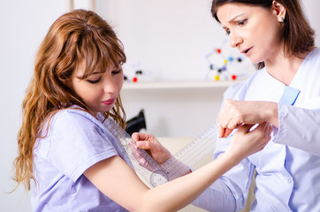 Female doctor checking patient's joint flexibility with goniomet