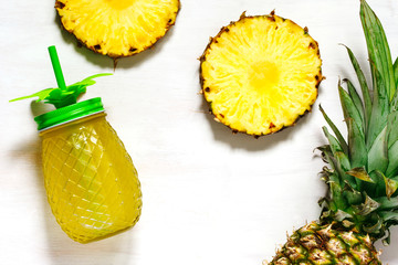 Pineapple juice and slices of fresh pineapple, top view, copy space