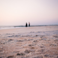 Fototapeta na wymiar Two People Walking on the Beach Waiting for Sunrise