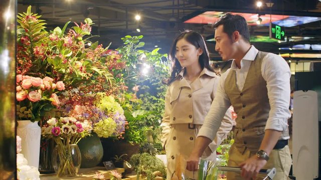 happy young asian couple buying flowers at a florist's shop
