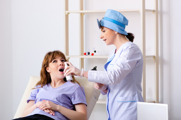 Young woman visiting female doctor otolaryngologist