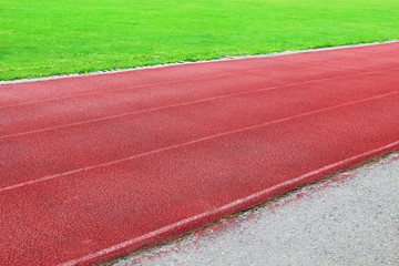 Red rubber running track in the stadium. Close-up. Background. Texture.