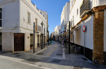 Obraz premium The narrow street of Rota city in sunny september day. Rota, Andalucia, Spain.