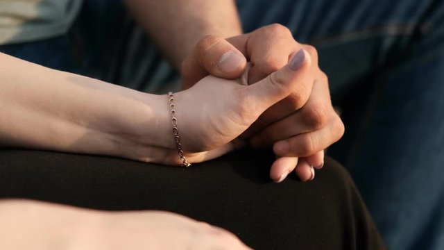 Close-up of the hands of a young couple in love.