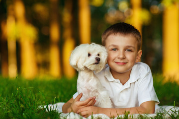 Little boy with a maltese puppy, outdoor summer