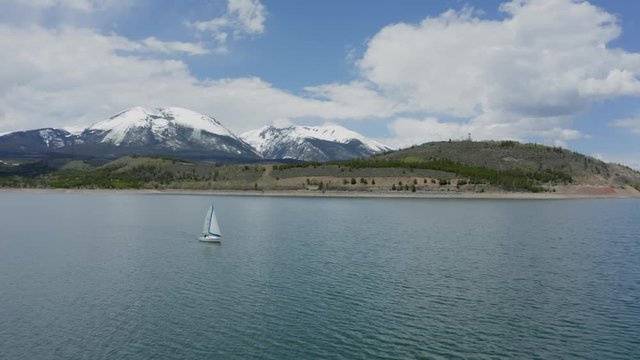 Aerial Flyby Shot of a Lone Sailboat on a Beautiful Mountain Lake in Colorado (Dillon Reservoir)