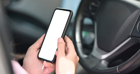 Cropped shot of woman using mobile phone inside the car