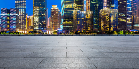 Empty square floor and modern office building at night in Shanghai