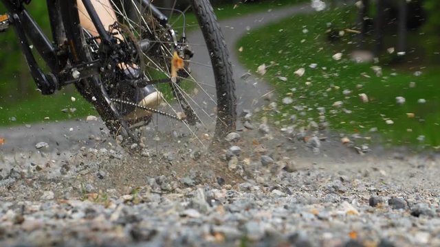 Rocks Flying When Cyclist Breaks Hard on Gravel Road Slow Motion