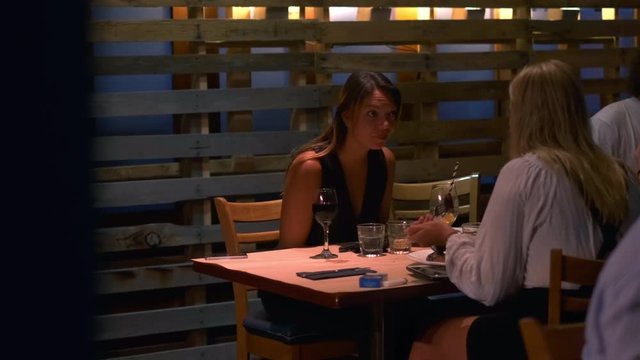 Slow motion rack focus shot of two young woman enjoying dinner