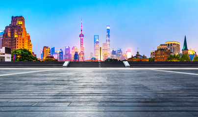 Shanghai skyline and modern city skyscrapers with wooden board square at night,China