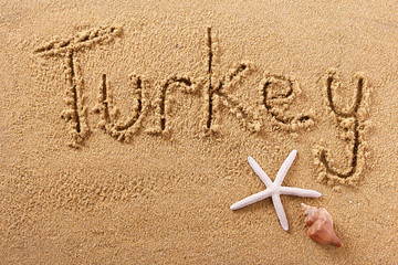 Fototapeta na wymiar Turkey word written in sand on a sunny turkish summer beach with starfish holiday vacation travel destination sign writing message photo