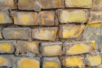 Colored bricks on the wall. Unusual mosaic on the fence. Decorated reinforced fence