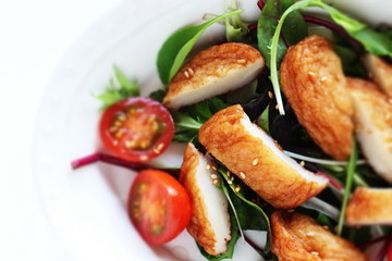 Asian food, fish cake and baby leaf salad