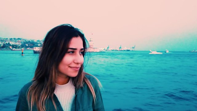 Slow motion:Beautiful young girl has a boat tour with view of bosphorus and Maiden Tower in istanbul,Turkey.