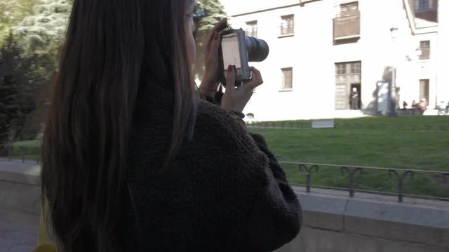 Young Latin tourist woman taking pictures in Madrid city centre