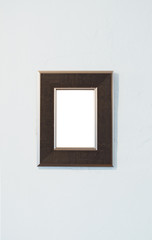 Wooden photo frame on the white room wall inside the building