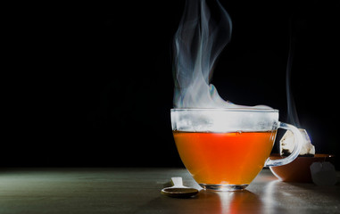 glass cup with tea infusion, on black background with label to write text