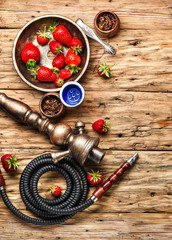 Smoking hookah on strawberry