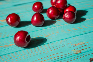 Plums on a wooden blue background.