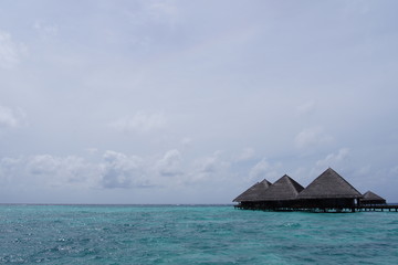 Water villas, cloudy sky and the Indian Ocean in cloudy weather