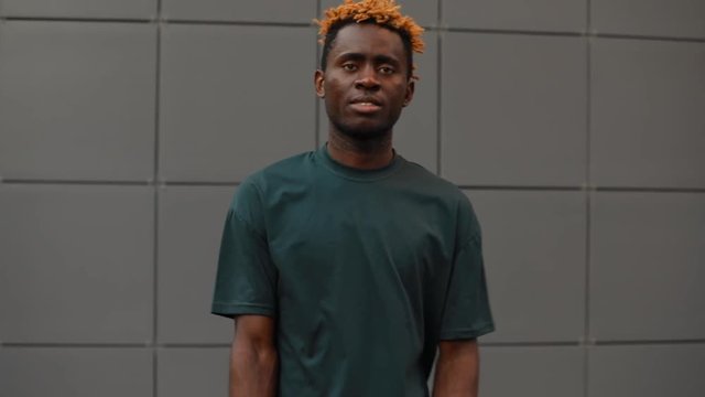 African model man posing in t-shirt near building wall