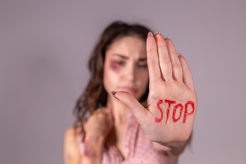 Domestic violence, protesting and people concept - brunette woman expressing denial with STOP on...