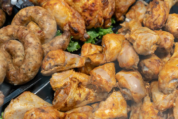 Roasted chicken and pork dishes are in the refrigerated display case in the supermarket