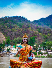 Idol of Indian God/ Goddess or deity, at the bank of river Ganga in Rishikesh with blurred temple in background , the yoga  capital of India. Indian Tourism  