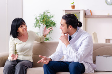 Young doctor examining senior old woman