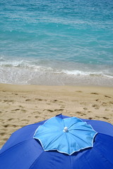 Parasol bleu sur la plage de sable.