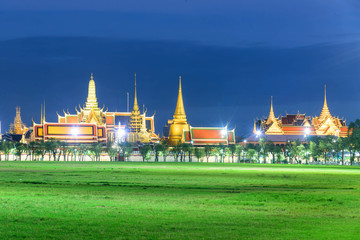 Naklejka premium wat pra kaew with green grass field and lighting in night time