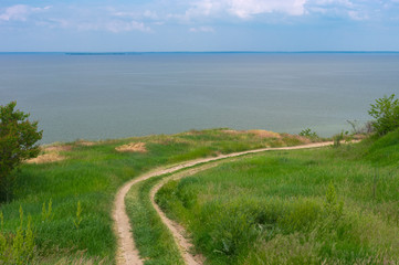 Spring landscape with an earth road leading to Kakhovka Reservoir located on the Dnipro river, Ukraine