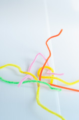 Neon colored pipe cleaners isolated on white background. messy and crumpled concept, metaphor.