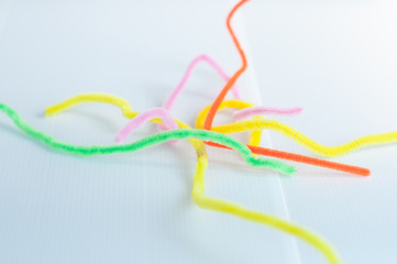 Neon colored pipe cleaners isolated on white background. messy and crumpled concept, metaphor.