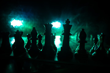 Chess board game concept of business ideas and competition. Chess figures on a dark background with smoke and fog.