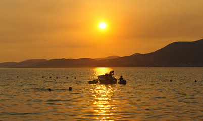 Sunset with a boat on the sea on Ciovo island in Croatia near Trogir city, Dalmatia