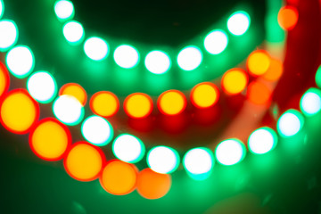 Red yellow green neon bokeh lights. Festive background of retro colors