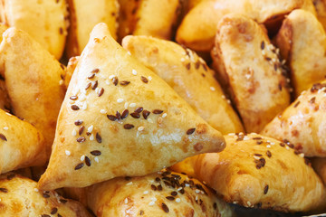 Triangle patty made of dough with ham and cheese or the national samsa dish with meat