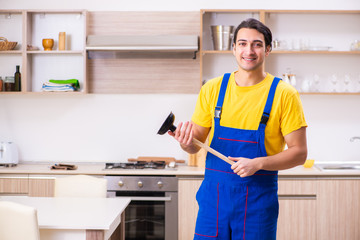 Young male contractor repairing tap at home 