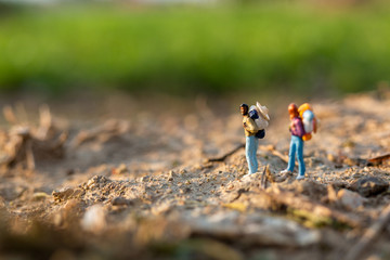 Miniature people : Traveler miniature with backpack stand and walking on meadow, Travel and Adventure concepts. 